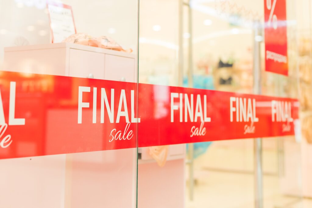 Close-up of a storefront with holiday sale signs